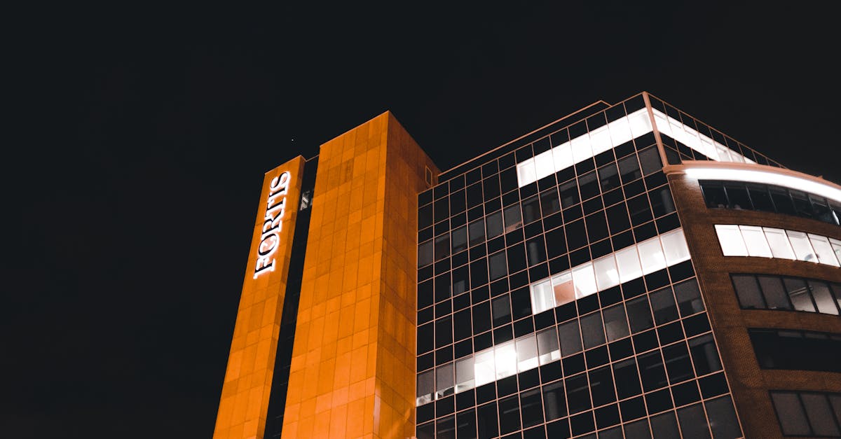 Night view of the Fortis building with illuminated facade and urban skyline.