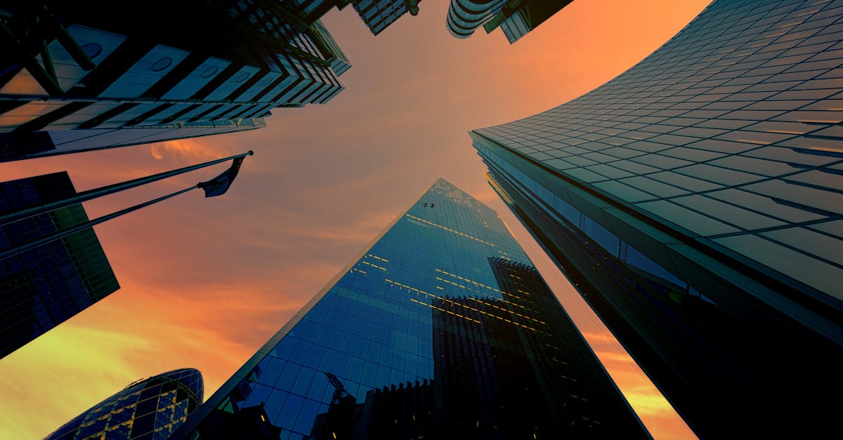 Low angle view of modern skyscrapers against a vibrant sunset sky.