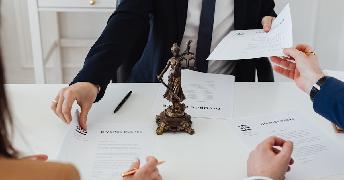 Three adults discussing divorce documents in a formal office setting with legal statue in view.