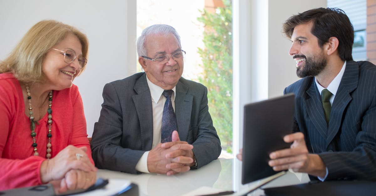 Elderly couple discussing real estate options with an agent in a modern office setting.