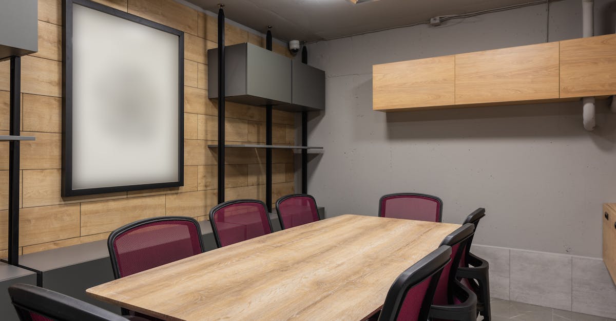 Contemporary meeting room interior with wooden table and sleek chairs.