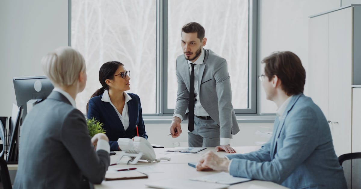 Professionals engaged in a serious business discussion in a bright office environment.