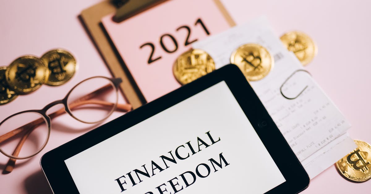 Tablet displaying 'Financial Freedom' surrounded by bitcoins and 2021 planner, symbolizing cryptocurrency potential.