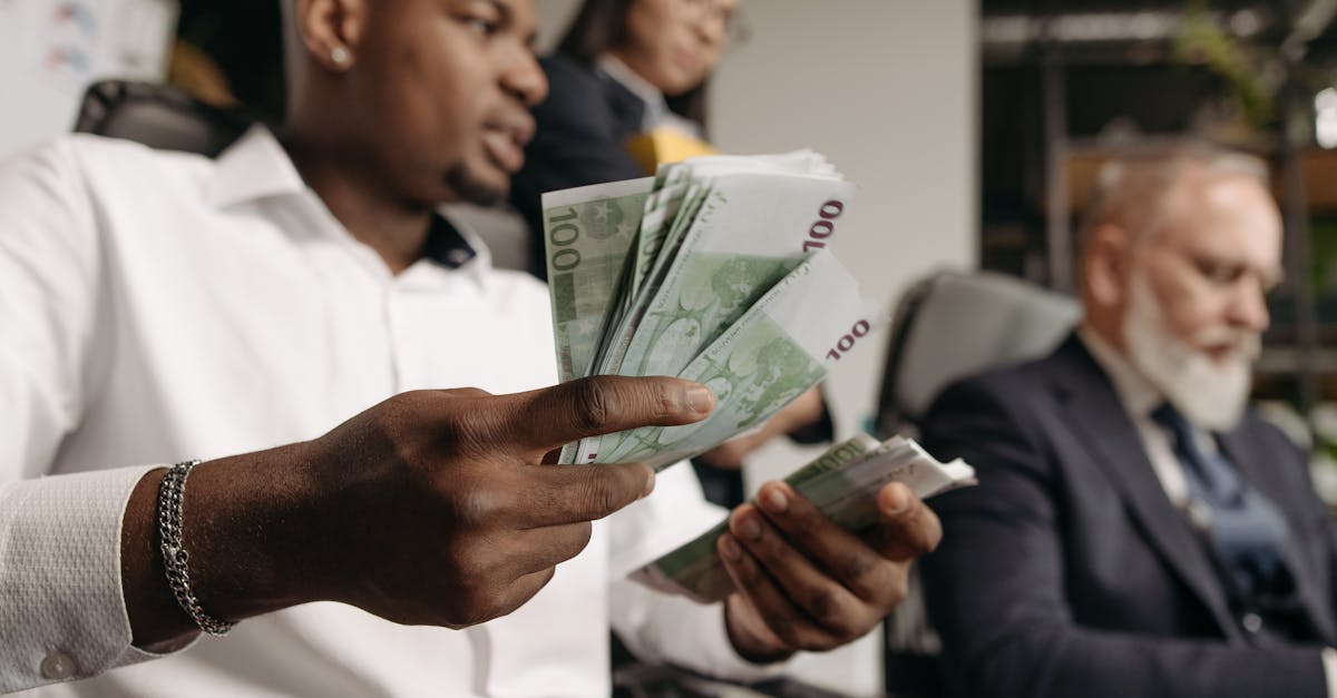 Three professionals in business attire counting cash in a modern office setting.