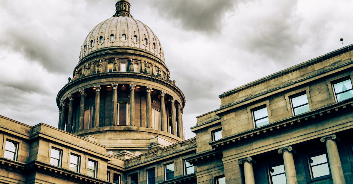 Stunning view of a classic capitol building with a prominent dome set against a dramatic, cloudy sky.