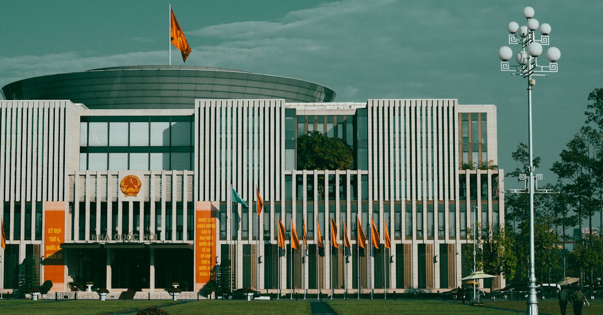 Front view of the National Assembly building in Hanoi, showcasing its modern architecture and national flags.