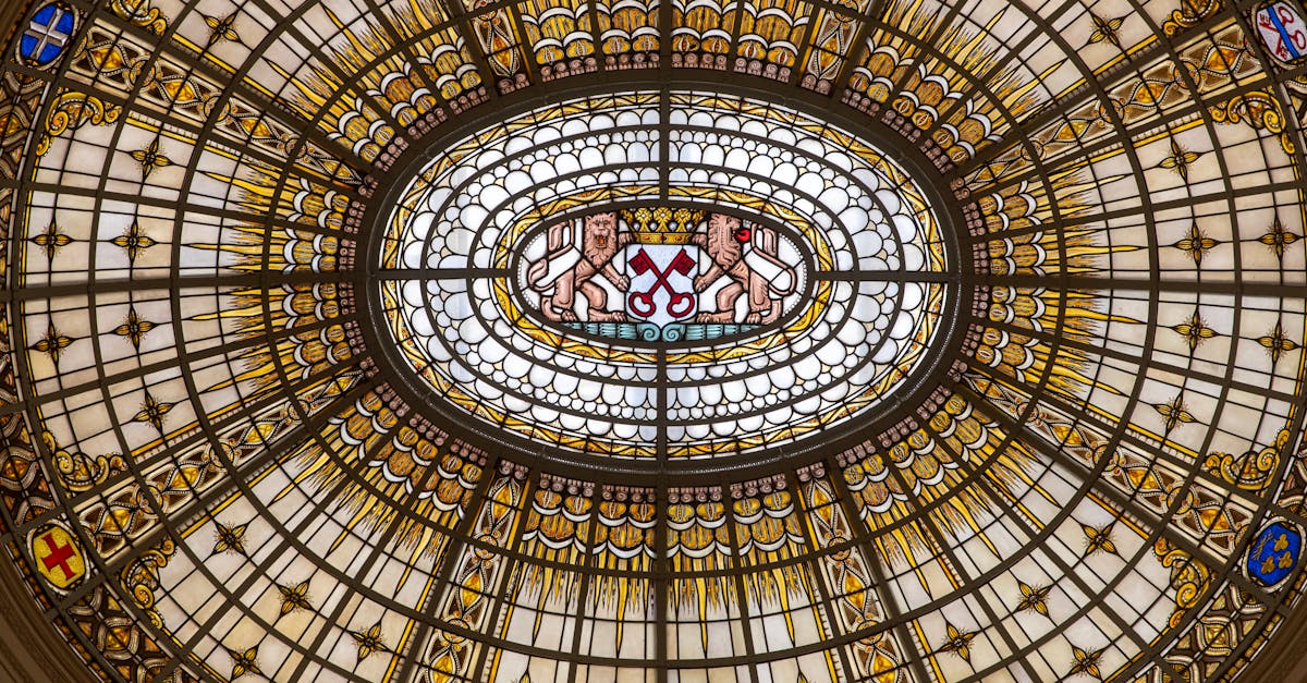 Ornate stained glass ceiling with golden highlights and a central heraldic emblem.