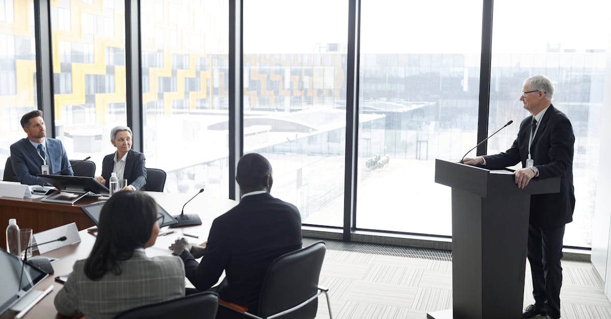 Corporate professionals engaged in a formal business meeting in a modern conference room setting.