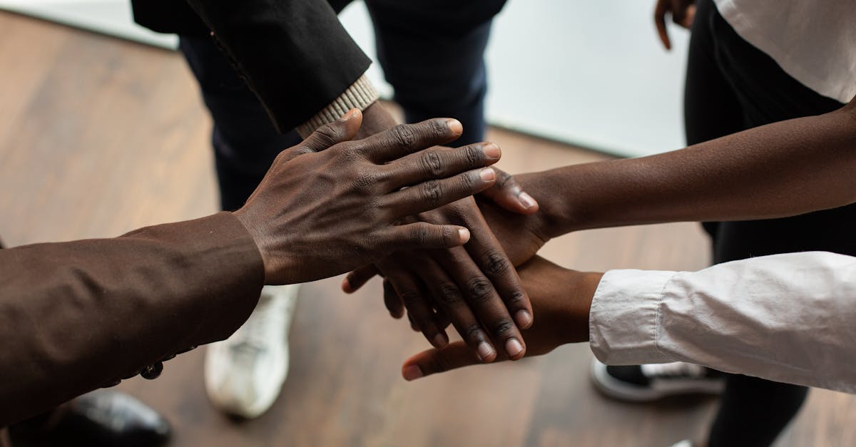 High angle view of diverse hands stacked together, symbolizing teamwork and unity.