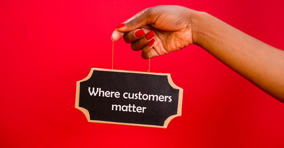 A sign with 'Where customers matter' held by a hand against a vibrant red background.