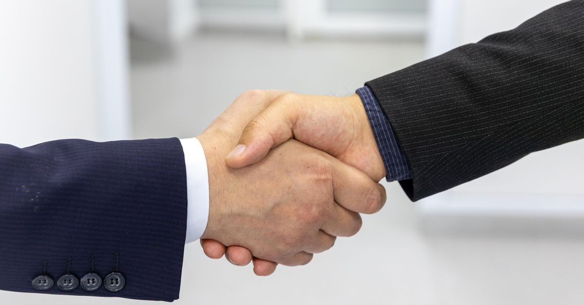 Close-up of a handshake in a business environment, symbolizing partnership.