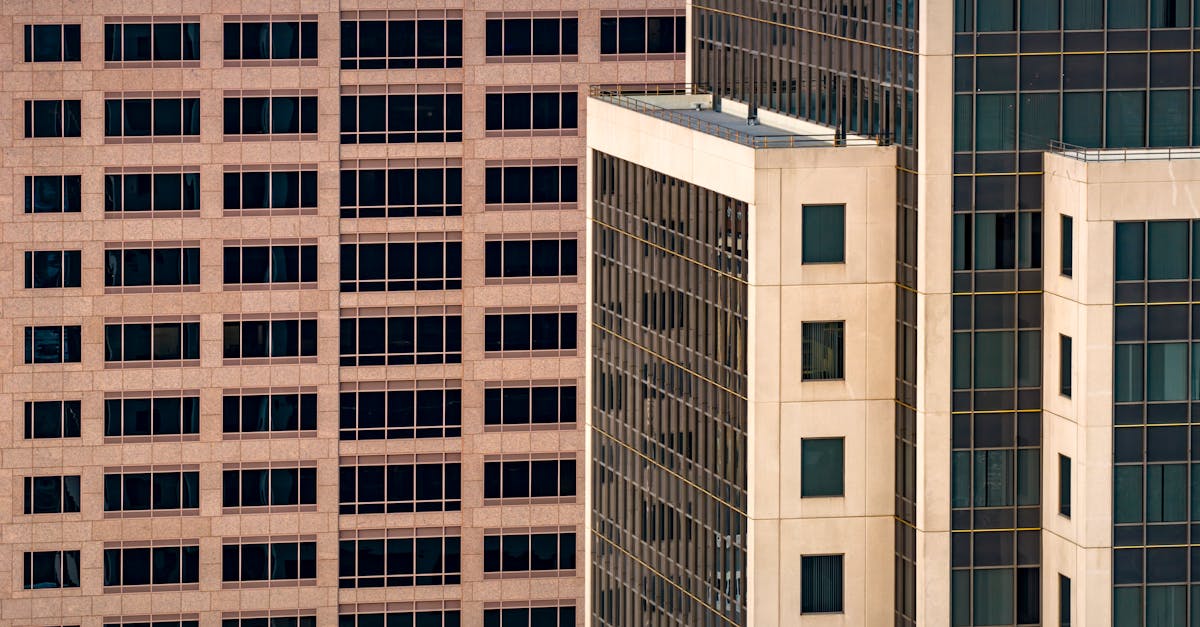 A modern office lounge with warm lighting, featuring mid-century furniture and floor-to-ceiling windows.