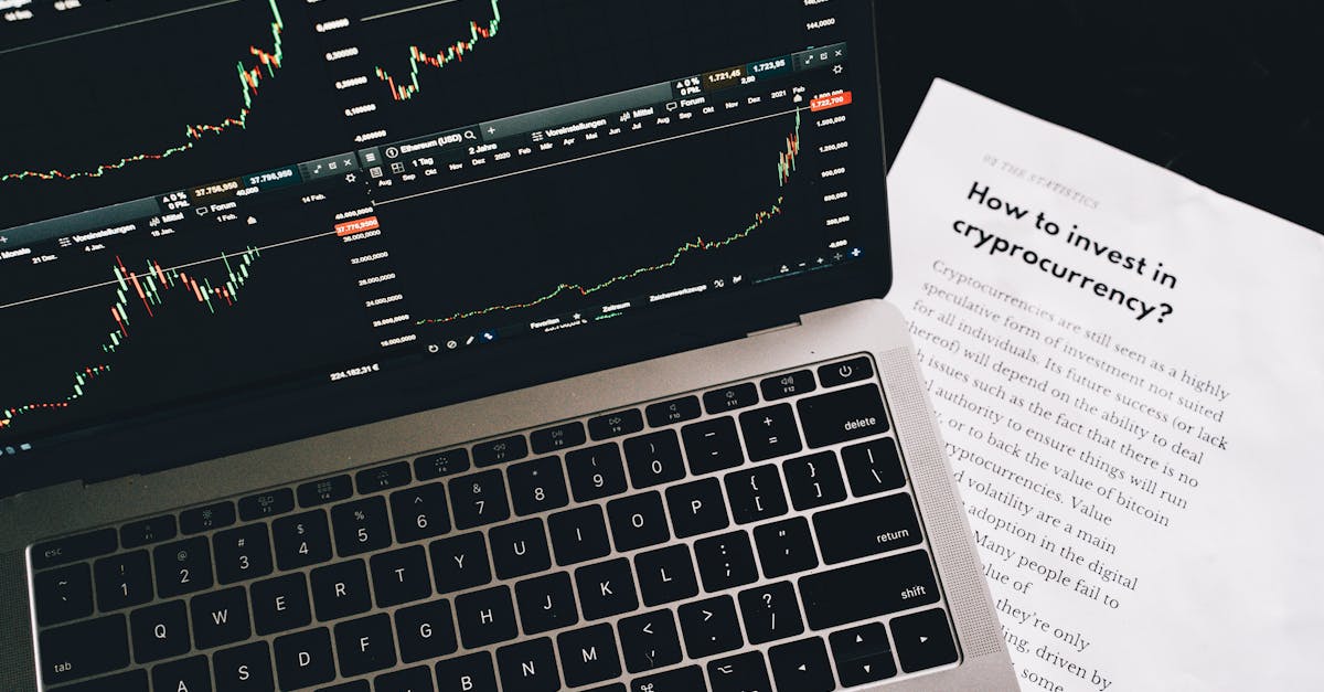 Close-up of a laptop displaying stock market graphs with a paper on investing in cryptocurrency, indoors.