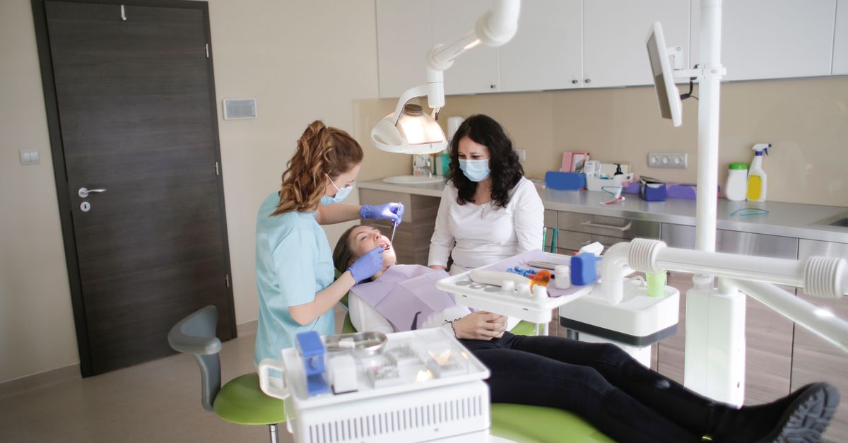 Female dentist performs treatment on a patient in a modern dental clinic.