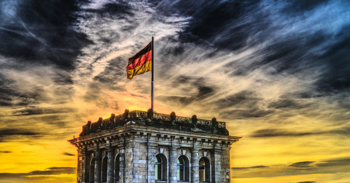 Vibrant sunset over a historic Berlin monument with the German flag waving.
