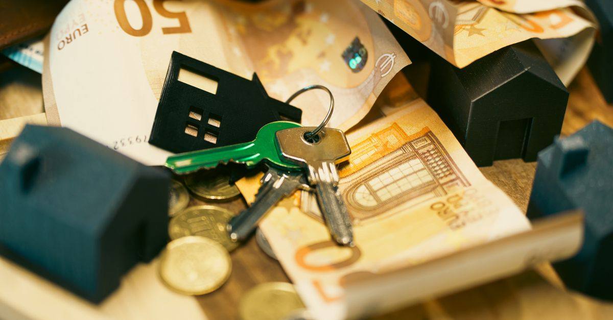Euro currency with house keys and miniature models, symbolizing real estate investment.