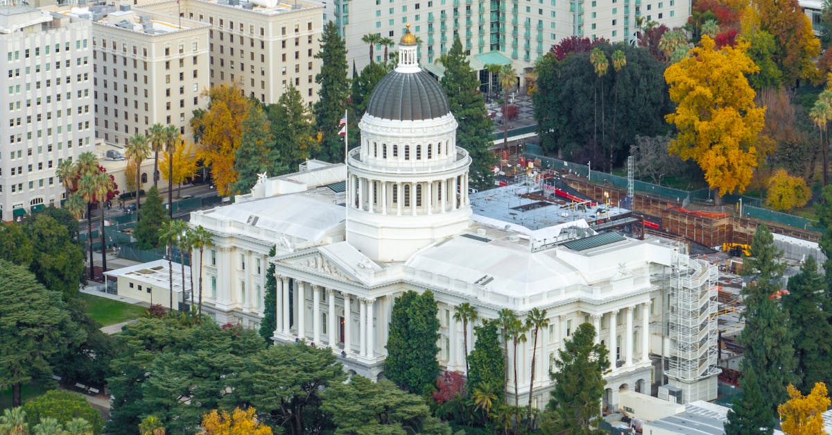 Aerial shot of the California State Capitol surrounded by colorful autumn foliage in downtown Sacramento.