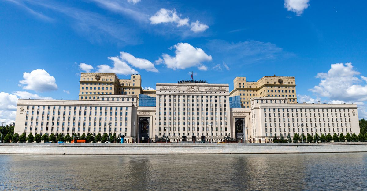 A majestic riverfront building captured on a sunny day with clear blue skies.