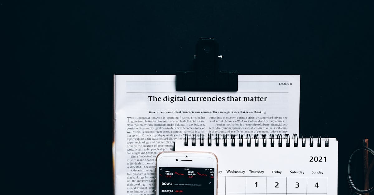 Digital currencies article with smartphone stock market app and calendar on black surface.