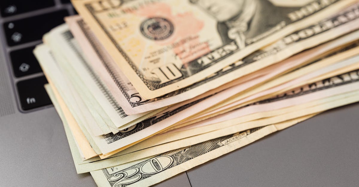 Stack of US dollar bills on a keyboard, symbolizing digital finance and wealth.
