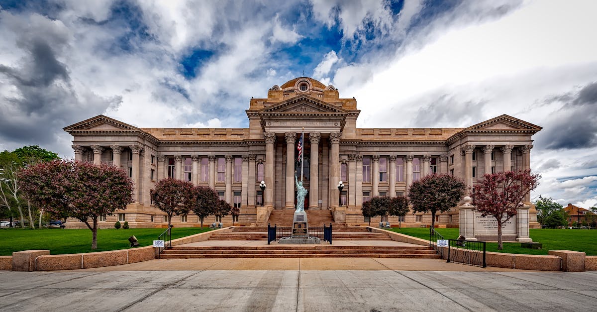 Front view of a neoclassical courthouse building in Colorado with lush greenery.