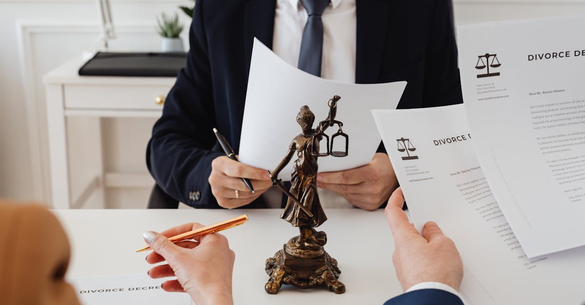 Legal professionals reviewing divorce documents in a law office with a Lady Justice statue.