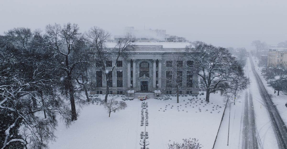 Historic courthouse blanketed in snow, captured on a serene winter day.