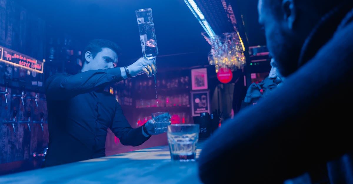 A bartender skillfully pouring drinks in a lively bar setting with patrons.