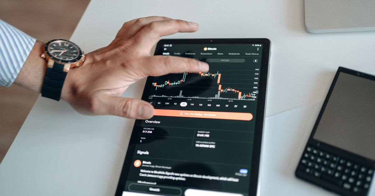 A person analyzing cryptocurrency market trends on a tablet device displaying digital charts.