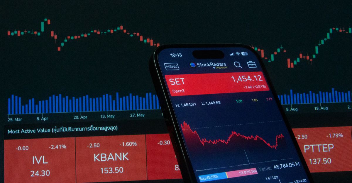 Mobile app showing stock market data with charts on screen.