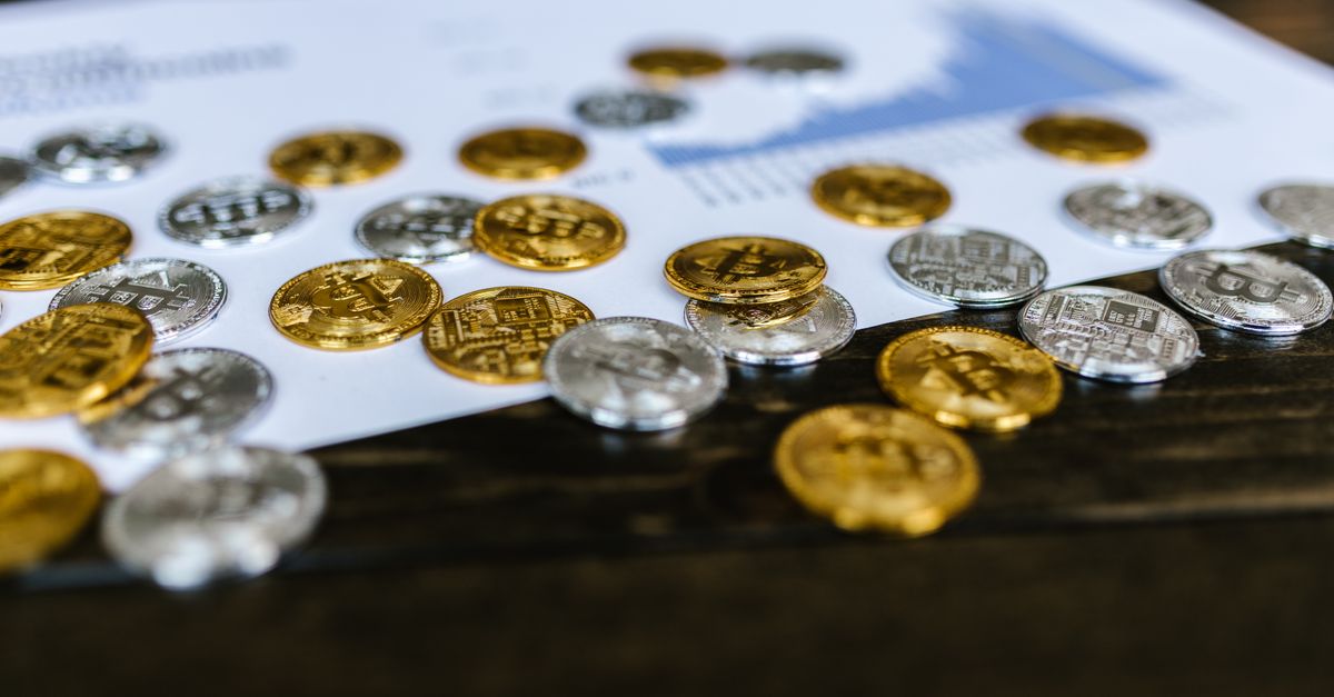 Digital currency coins on a paper chart, showcasing financial growth insights.