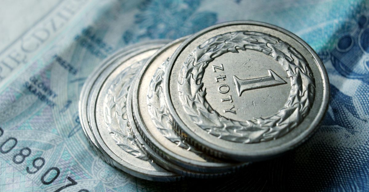 Close-up of Polish zloty coins stacked on a banknote. Financial concept.
