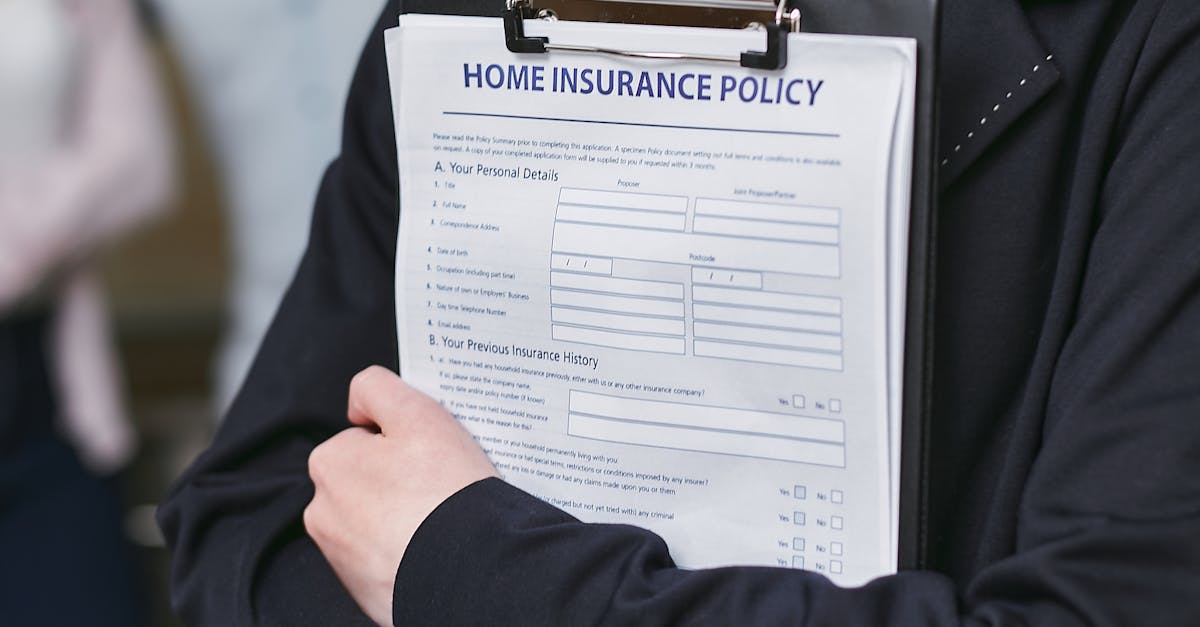 Close-up of a person holding a home insurance policy on a clipboard, captured indoors.