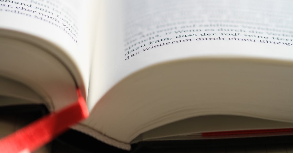 Open book with focus on page and red bookmark for reading and study.