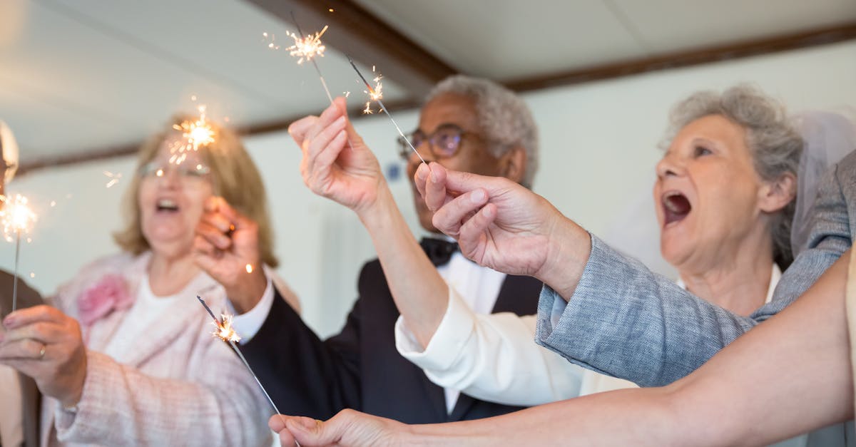 Elderly friends joyfully celebrate indoors holding sparklers. Embracing togetherness and fun.