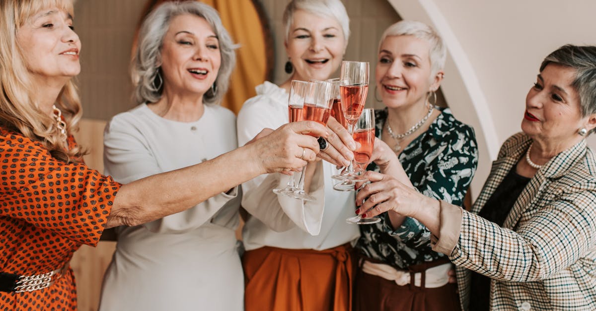 A group of senior women celebrating with a toast of champagne indoors, radiating happiness and togetherness.
