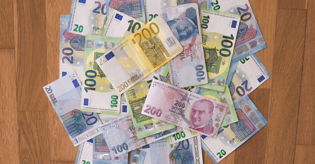 A pile of Euro and Turkish Lira banknotes scattered on a wooden surface, showcasing various denominations.