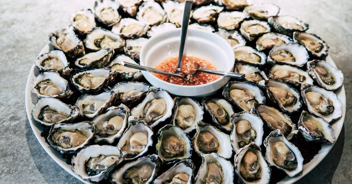 A stunning platter of fresh oysters with a tangy sauce, perfect for gourmet seafood enthusiasts.