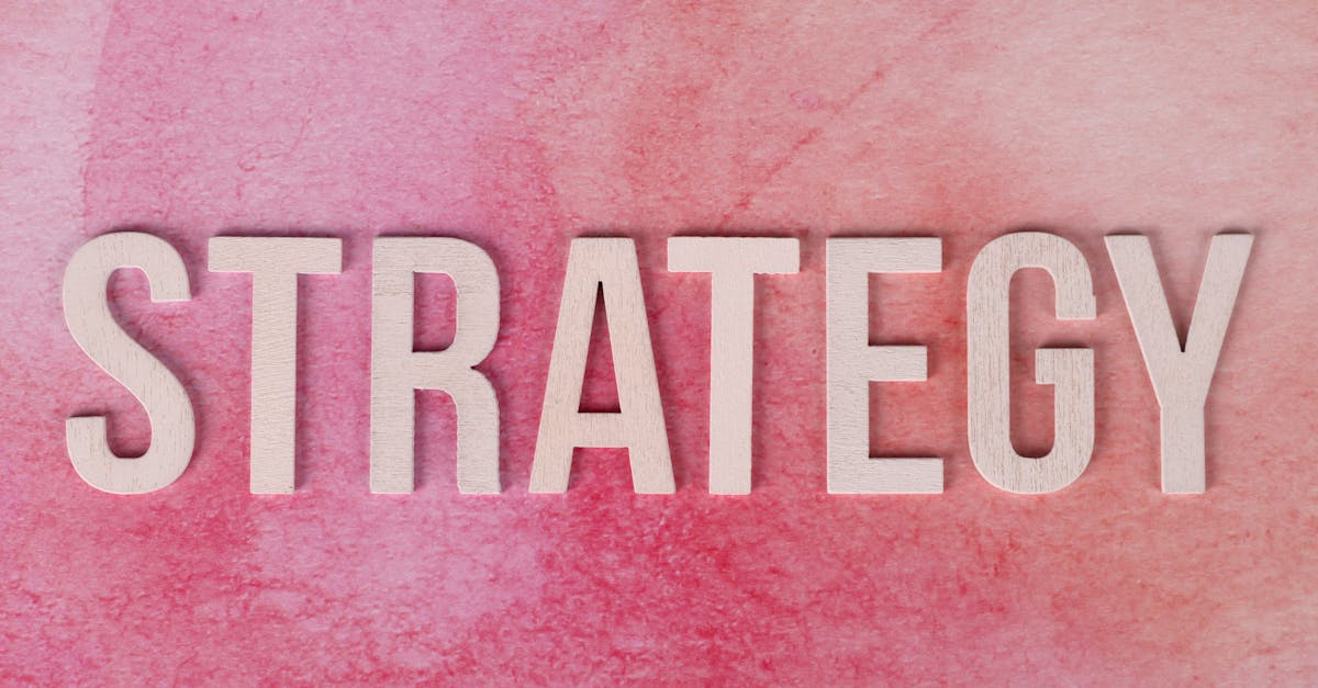 Wooden letters spelling 'Strategy' on a pink textured background.