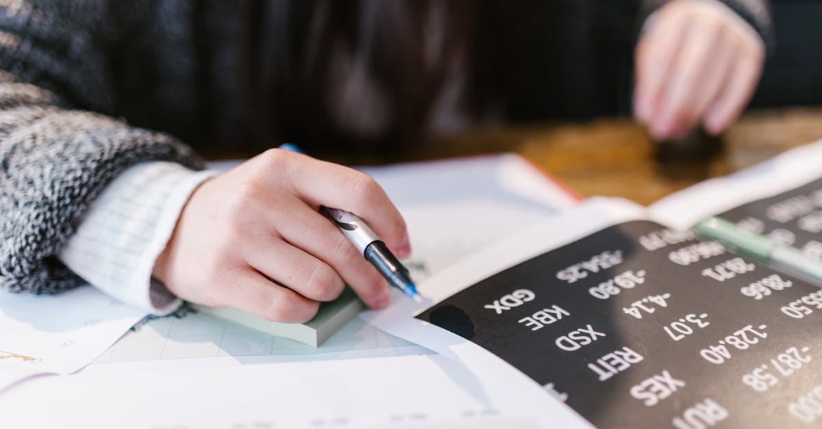 Close-up of a woman reviewing financial documents with focus on numbers and calculations.