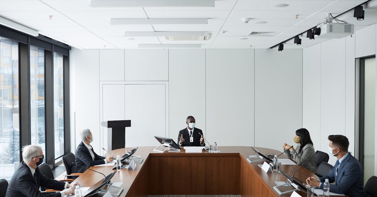 Business professionals in a conference room meeting wearing masks, emphasizing diversity and cooperation.