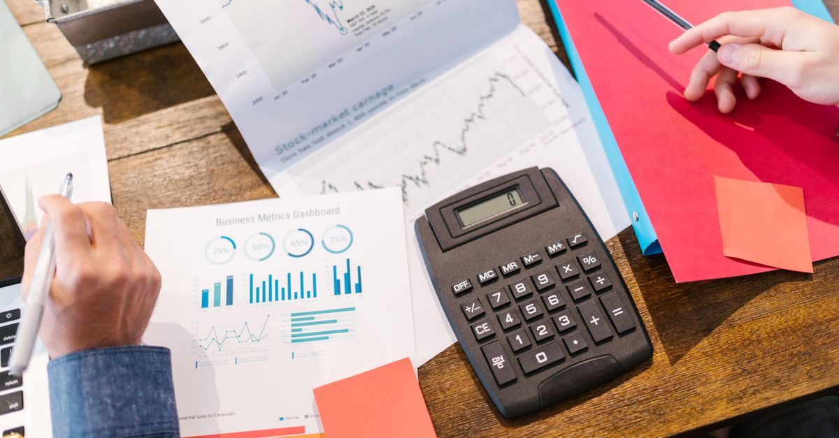Financial analysis and planning tools with graphs and calculator on a table.