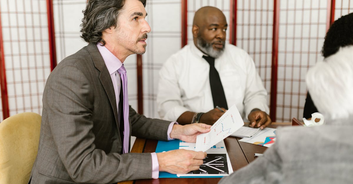 Colleagues discussing business reports during an office meeting.