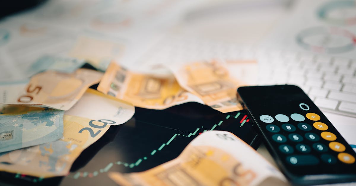 Euro banknotes scattered on a trading chart with a calculator, symbolizing finance and analysis.