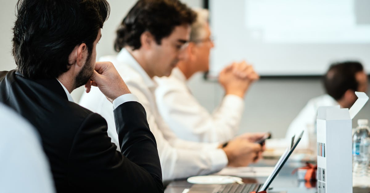 Corporate professionals in a formal meeting environment, focused on teamwork and collaboration.