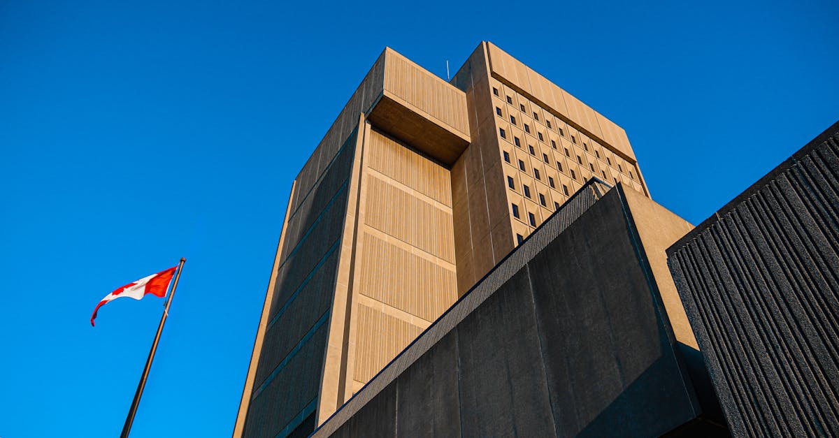 Low-angle shot of modern courthouse architecture with Canadian flag in London, Ontario.