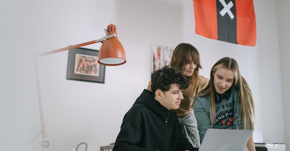 A diverse group of young adults collaborating on a project in a modern office setting.