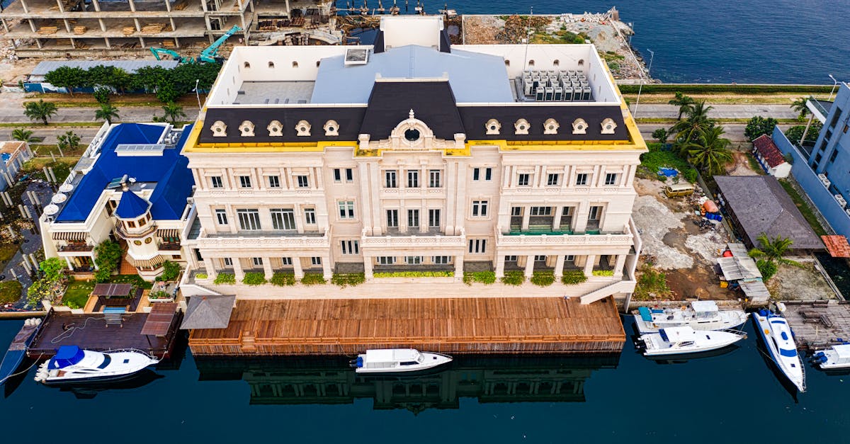 A stunning aerial shot of a coastal resort with yachts docked alongside a vibrant building.