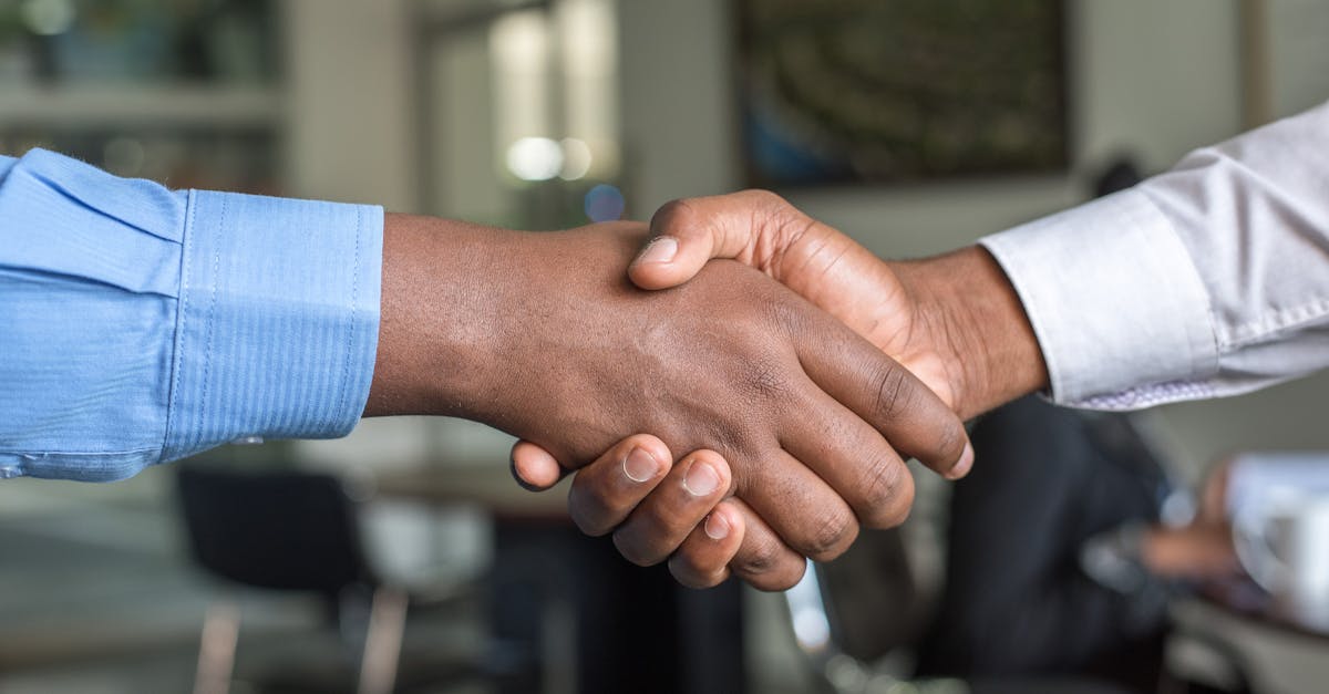 Close-up of two men's handshake symbolizing agreement in an office.