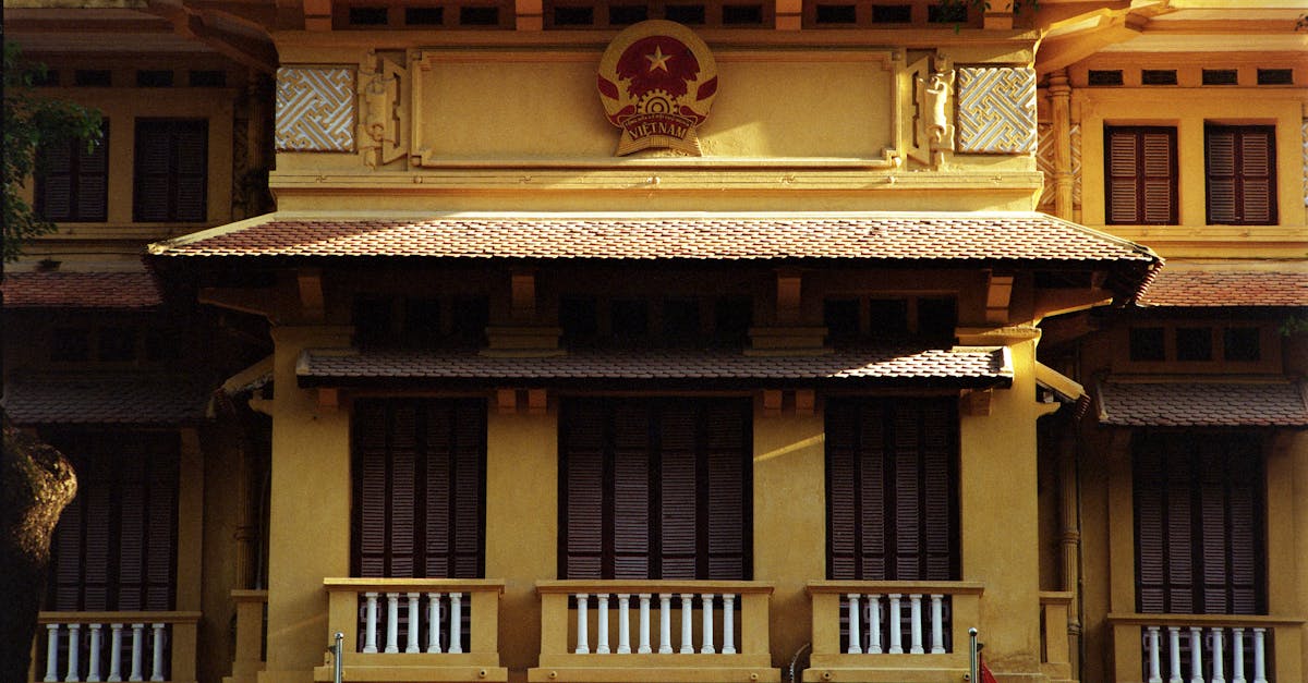 Detailed view of a colonial building with Vietnamese flag in Hanoi.